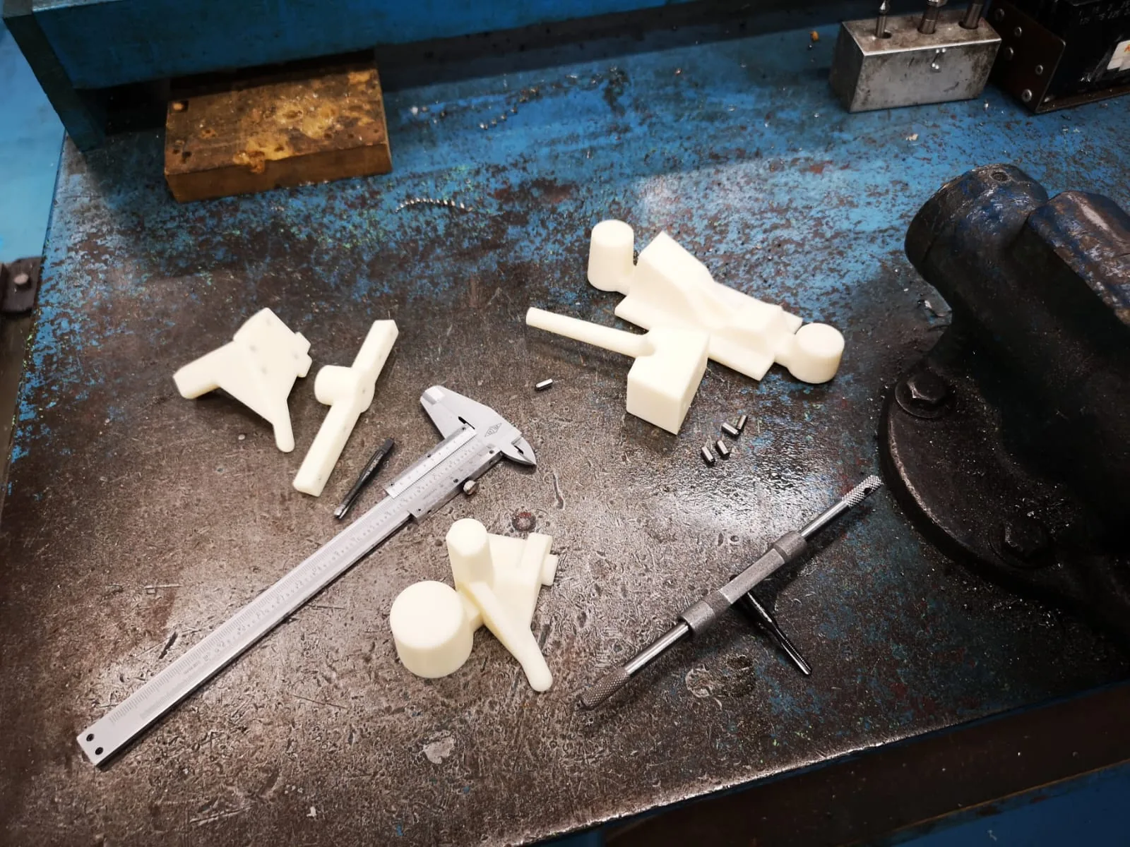 Workbench with 3D-printed parts, callipers and a tap